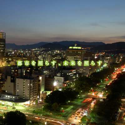 山光電設工業株式会社 様 会社案内制作実績：夜景を背景に輝く、山光電設工業のロゴ